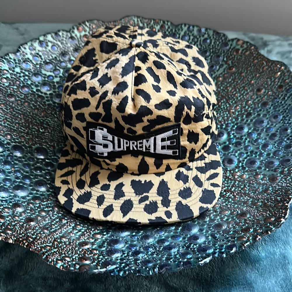 SUPREME cheetah snap hat with adjustable snaps in back.